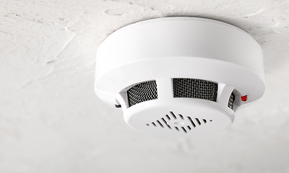 Modern smoke detector on ceiling